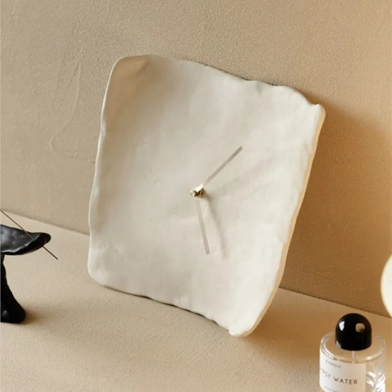 Vit oregelbunden klocka med minimalistisk urtavla