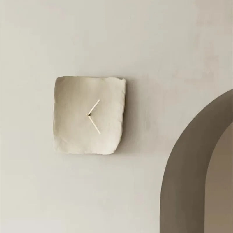 Vit oregelbunden väggklocka i minimalistisk interiör